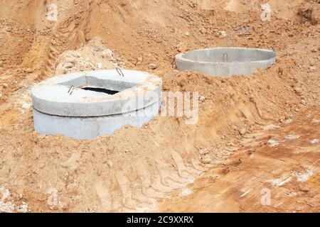 Construction of a sewage system for draining sewage from the road using reinforced concrete rings, outdoor Stock Photo