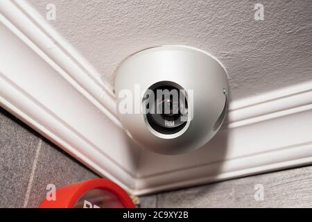 A security camera in the top corner of a door Stock Photo