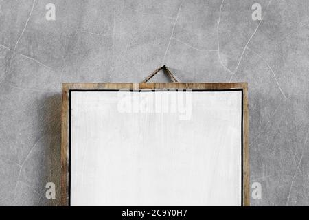 White wooden empty board hanging on gray concrete cement wall. Place for logo, sign or text. Stock Photo