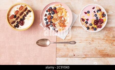 Bowls of yoghurt with various fruits and nuts Stock Photo