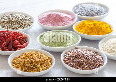 Various superfoods in small bowls on white wooden background. Healthy food concept Stock Photo