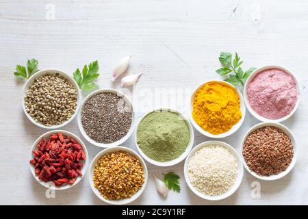 Various superfoods in small bowls on white wooden background. Healthy food concept Stock Photo