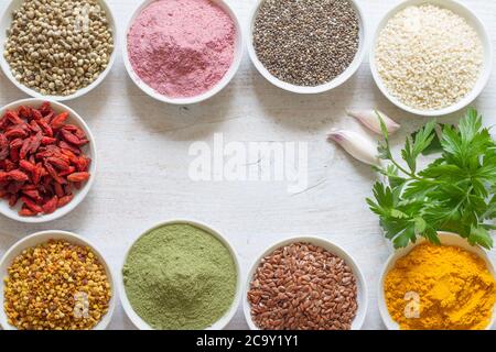 Various superfoods in small bowls on white wooden background. Healthy food concept Stock Photo