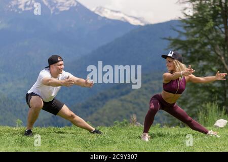 fitness, sport, people, exercising and lifestyle concept - couple doing join workout squats on city street stairs Stock Photo