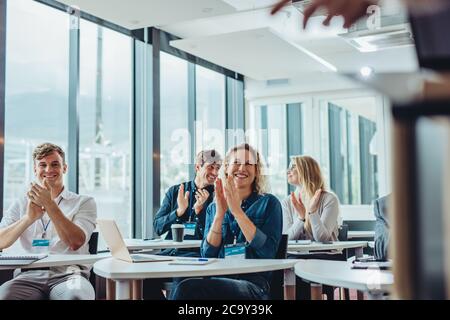 Businesspeople clapping hands in seminar. Audience applauding after successful conference. Stock Photo
