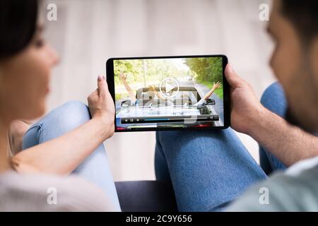 Young People Watching Streaming Videos On Tablet Stock Photo