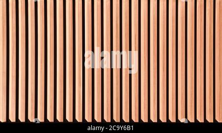 Wooden background close-up. Wooden laths are natural material. Relief texture of brown background. Vertical photo of a embossed texture. Relief Stock Photo
