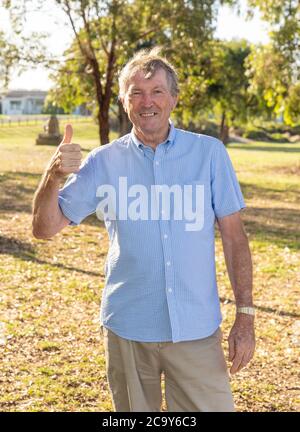 Outdoors portrait of Beautiful retired older man at the park on sunset enjoying his health and freedom feeling happy and lucky in healthy and active l Stock Photo