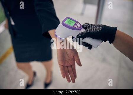 Airport worker checking body temperature of female traveler Stock Photo