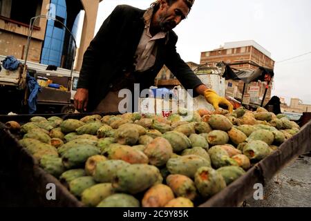 (200803) -- SANAA, Aug. 3, 2020 (Xinhua) -- A vendor prepares prickly pear fruits on his wheelbarrow as he waits for customers at a street in Sanaa, Yemen, on July 21, 2020. TO GO WITH 'Feature: Prickly pear fruit in Yemen provides livelihoods despite war, blockade' (Photo by Mohammed Mohammed/Xinhua) Stock Photo