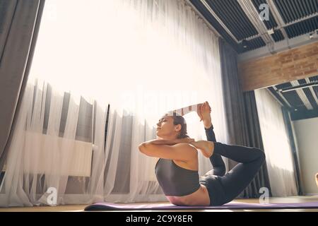 Beautiful serene woman practicing yoga in studio Stock Photo