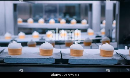 Icecream automatic production line - conveyor belt with ice cream cones at modern food processing factory. Food dairy industry, manufacturing Stock Photo