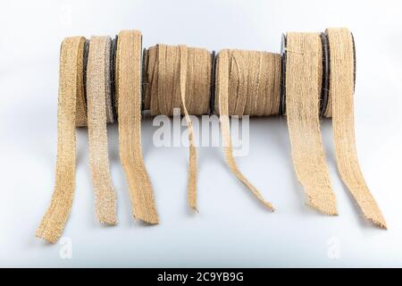 Colored jute ribbon rolls isolated on white background. Natural Braided Hemp Rope Vintage Linen Ribbon Roll, Linen Ribbon For Gift Wrap. Stock Photo