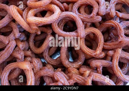 Turkish Dessert Churros Halka Tatli frying in hot oil. Turkish doughnuts or traditional ring sweet - 'Halka Tatli, kerhane tatlisi.' Stock Photo