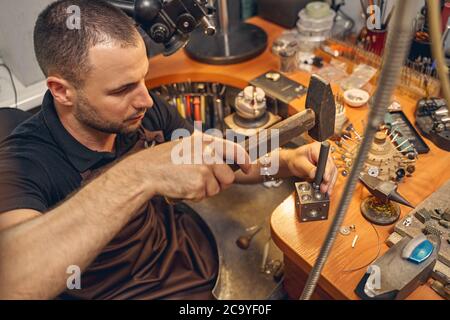 Serious young man using a metal working tool Stock Photo