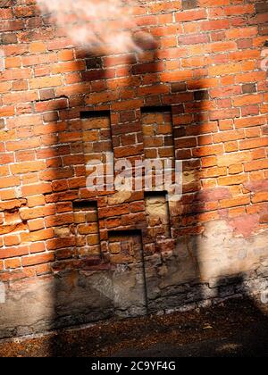 Shadow of a house on a wall with windows and door, smoke coming out the chimney Stock Photo