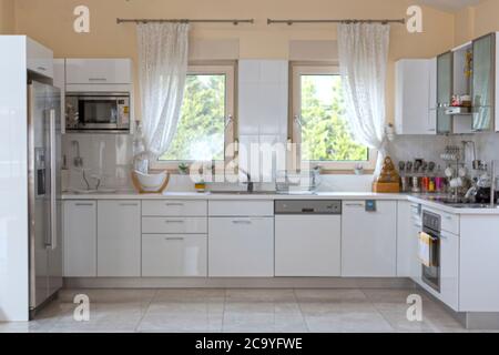 Blurred Kitchen Interior in Light Tones with White Furniture Stock Photo