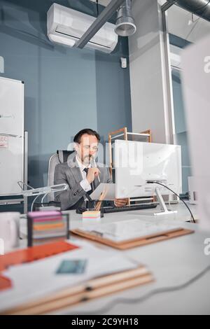 Handsome serious man studying documents at work Stock Photo
