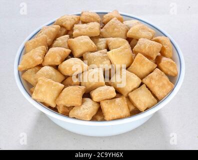 Shakkar pare Also Know as Shakkarpare, Shakarpare, Shakarpali, Shakkar Para, Sakarpara or Shankarpalli or shankar pale is a Snack Typically Stock Photo