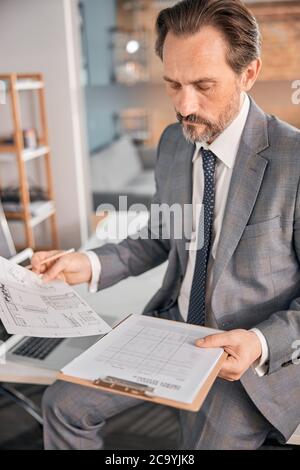 Handsome bearded man studying documents at work Stock Photo