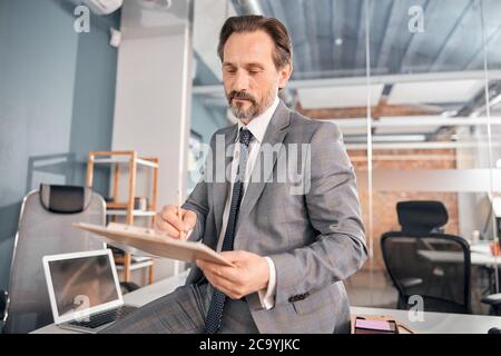 Handsome male worker studying documents in office Stock Photo