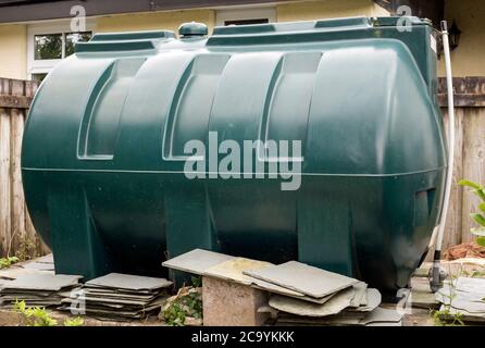 Shot of a large green plastic oil tank in a rural garden in Cornwall, England. Stock Photo