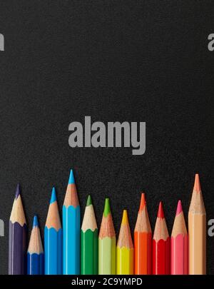 Multi-colored pencils on blackboard Stock Photo