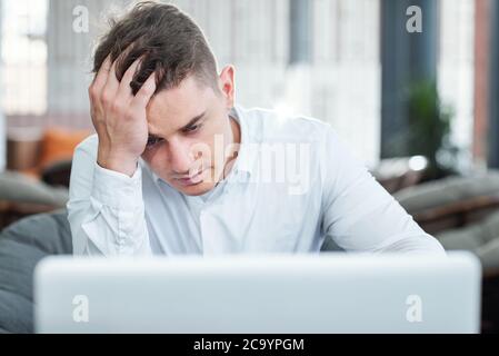 Stressed and tired young businessman did not save the document he was working on all day long Stock Photo