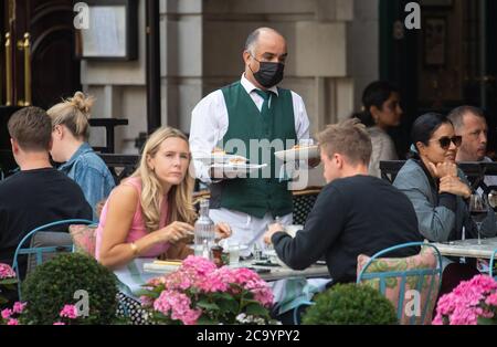 Diners eat outside the Ivy Market Grill, in London, one of the participating restaurants where diners will be able to enjoy half-price meals, starting on Monday as the Government kick-starts its August scheme aimed at boosting restaurant and pub trade following the lockdown. Stock Photo