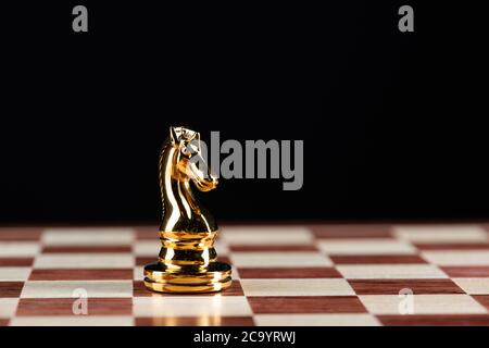 Premium Photo  The golden horse, knight chess piece standing in front of  silver pawn chess pieces on chessboard on dark background. leadership,  follower, team, commander, competition, and business strategy concept.