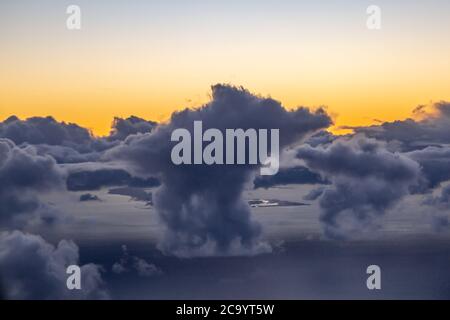Dramatic clouds over the ocean at sunset, viewed from an airplane Stock Photo