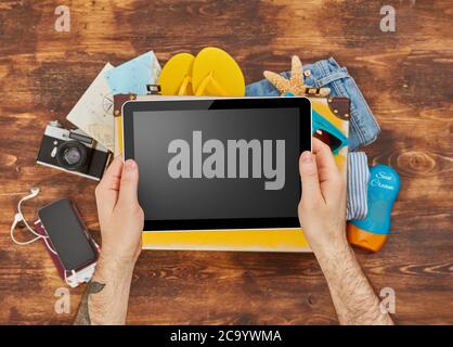 Digital tablet, suitcase, clothing and personal accessories Stock Photo
