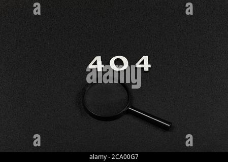 Numerals 404 and magnifying glass on black background. Error concept Stock Photo