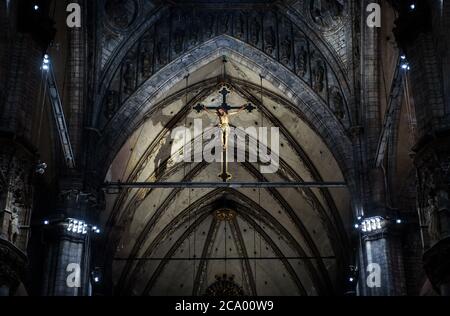 Milan, Italy - May 16, 2017: Statue of crucified Jesus Christ inside Milan Cathedral. Holy cross in interior of dark Catholic church, view of crucifix Stock Photo