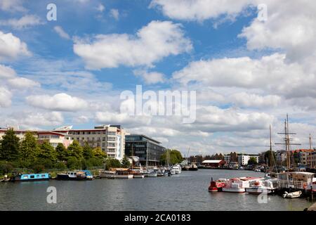 View along the River Avon into Bristol city. Boats and historic ships are moored. Bristol, England. July 2020 Stock Photo