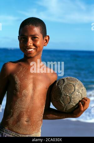 Young brazilian boy playing football on a parking lot in Rio de Janeiro