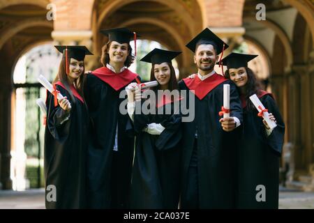 Happy students with diplomas after graduation ceremony outdoors Stock ...