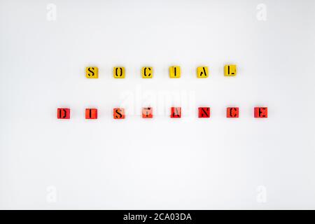 Yellow and red wooden cubes with message Social Distancing isolated on white background Stock Photo