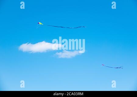 Child's toy kite flying in a clear blue summer sky Stock Photo