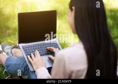 Mockup Image Of Woman Working On Laptop With Black Screen Outdoors Stock Photo
