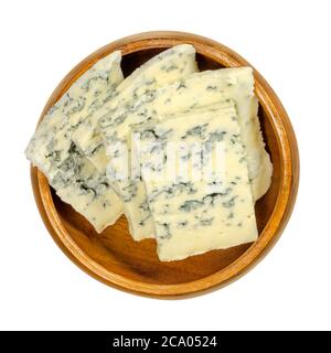 Blue cheese slices in wooden bowl. Bleu cheese made with cultures of mold Penicillium, giving it spots or veins, which can vary in color. Stock Photo