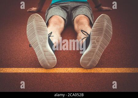 Man runner resting after workout session on the running track Stock Photo