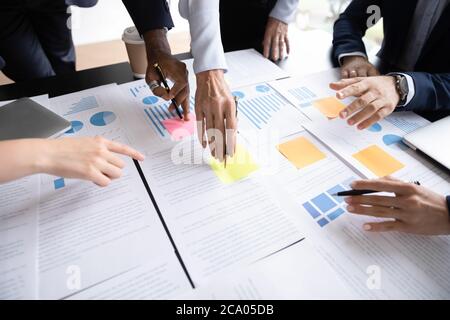 Closeup view diverse businesspeople discuss paperwork data statistics at meeting Stock Photo