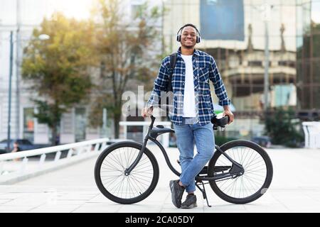 Portrait of black guy standing with his bike Stock Photo