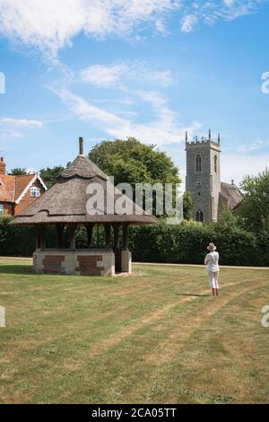 Woodbastwick village, view across the village green in Woodbastwick towards the thatched parish church of Saints Fabian and Sebastian, Norfolk, UK Stock Photo