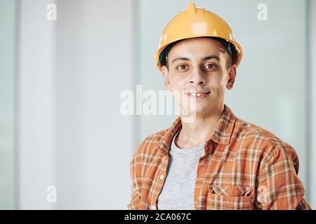 Young middle eastern construction engineer in hardhat smiling and looking at camera Stock Photo