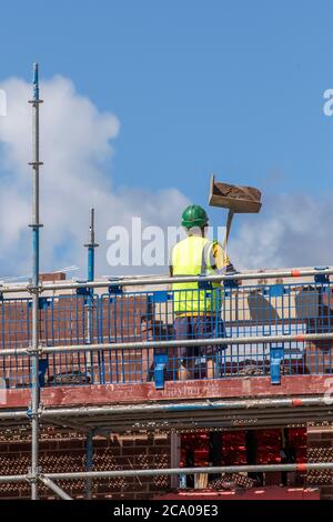 Builders working in Tarleton, Lancashire.  UK Weather. Hot summer sun for new build housing estate development in the new Persimmon housing Estate in Douglas Gardens. A major development that may be put on hold depending on the severity of the impending recession.  Contractions are expected to be sharpest in private housing (-42 per cent), commercial and private housing repair, maintenance and improvement , these are the sectors that are most closely linked to consumer and business confidence, likely to be significantly dented by fading job security and rising unemployment. Stock Photo