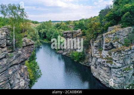 the river flows through a canyon with large stones and rocks Stock Photo