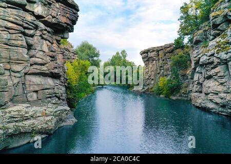 the river flows through a canyon with large stones and rocks Stock Photo