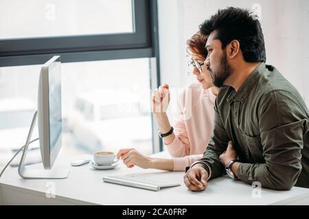 Male and female business colleagues working together on hard problem in office Stock Photo